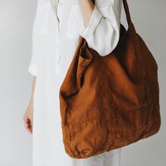 a woman is holding a brown bag in her hand