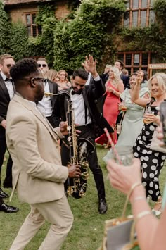 a man in a suit and tie playing a saxophone