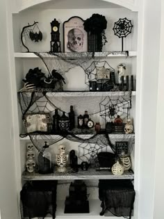 a white shelf filled with lots of halloween decorations and decor on top of each shelf