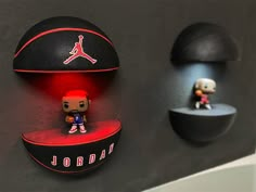 the jordan basketball is on display next to two other figurines, one in red and black