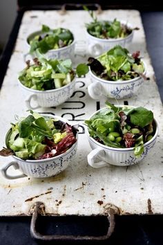 several bowls filled with salad sitting on top of a table