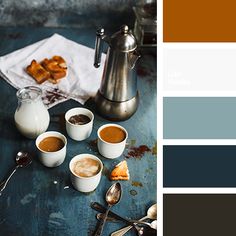 a table topped with cups of coffee next to spoons and utensils on top of a blue surface