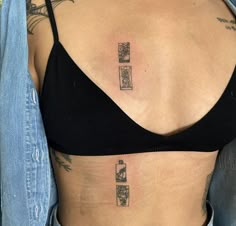 a woman with tattoos on her stomach wearing a black bra