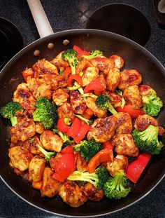 a pan filled with chicken, broccoli and tomatoes