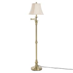 a floor lamp with a white shade on the base and a cord attached to it