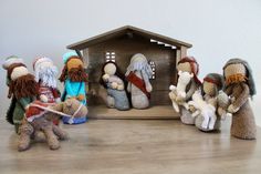 several crocheted nativity figurines are displayed on a wooden table with a white wall in the background