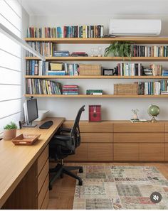 a home office with bookshelves, desk and computer on the far wall in front of an air conditioner