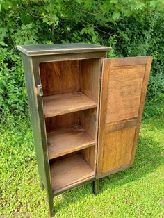 an old wooden cabinet sitting in the grass