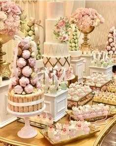 a table topped with lots of cakes and cupcakes