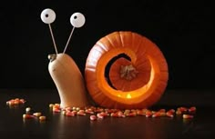 a snail carved into a pumpkin with the word love spelled in front of it and two eyes on each side