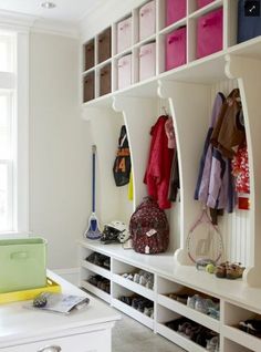 a room with some white shelves filled with shoes and bags on top of them,