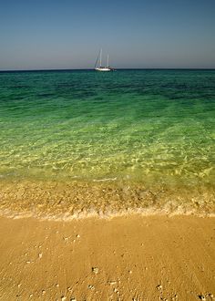 there is a boat that is in the water on the beach near the shore line