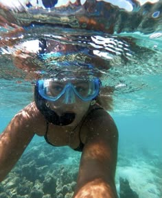 a woman swimming in the ocean with her snorkels and goggles on