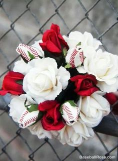 a baseball and roses bridal bouquet on a fence