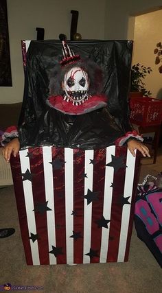 a child dressed up as a clown in a box with stars and stripes on it