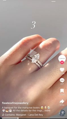 a woman's hand holding a diamond ring with the number 3 on it,