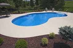 an above ground swimming pool surrounded by landscaping