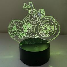 an illuminated motorcycle is shown in the shape of a lamp