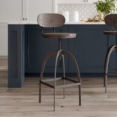 two stools in the middle of a kitchen with blue cabinets and white countertops