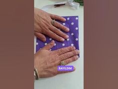 two hands on top of a purple and white polka dot paper with the words mid - way written on it