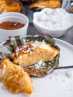 a close up of a plate of food with rice and other dishes in the background