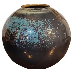 a brown vase with blue speckles on it