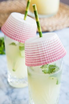 two glasses filled with drinks sitting on top of a table