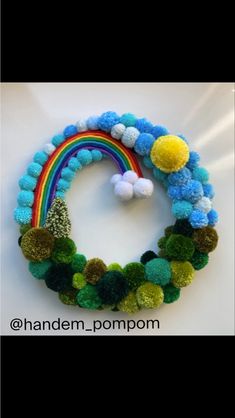 a bracelet with pom poms and a rainbow in the middle on a white surface