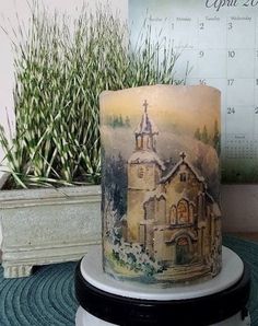 a candle that is sitting on a table next to a potted plant and calendar