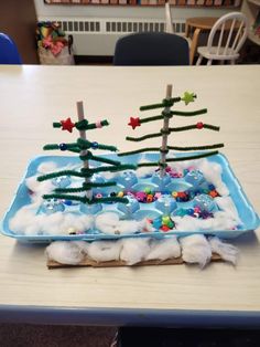 a tray with cotton balls and christmas trees on it, sitting on a table in the middle of a room