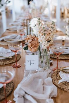 the table is set with flowers and place cards