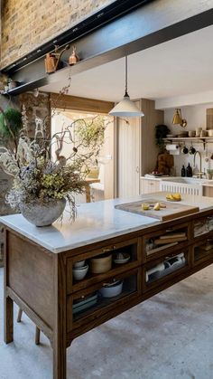 a kitchen with an island in the middle and shelves on the wall behind it,