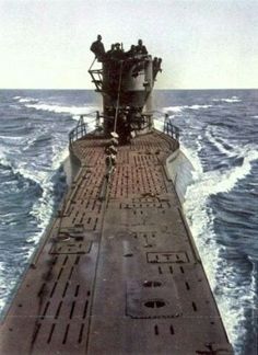 an old photo of a ship in the ocean with men on it's deck