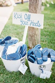 two buckets filled with blue plates next to a sign that says kick off your heels