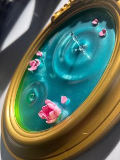 a close up of a clock with flowers on it's face and water in the middle