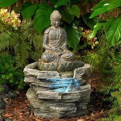 a buddha statue sitting on top of a rock fountain