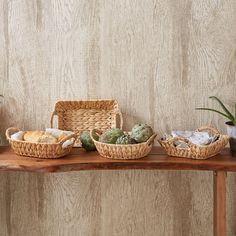 three wicker baskets sitting on top of a wooden table with succulents