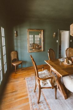 a dining room table with chairs and a rug on the floor in front of it