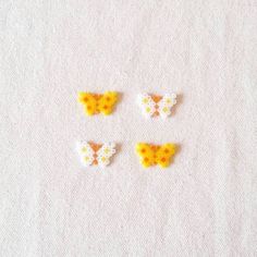 four small yellow and white butterfly shaped beads