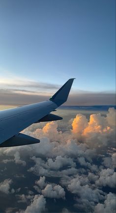 the wing of an airplane flying over clouds