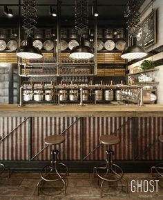 an industrial style bar with stools in front of it