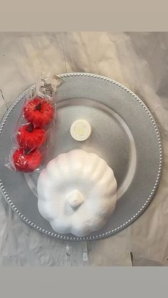 a silver plate topped with red berries next to a bag of white powdered sugar