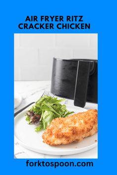 an air fryer sitting on top of a white plate next to a green salad