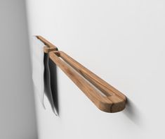 a close up of a wooden handle on a white wall with a black object in the background