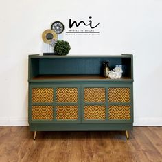 a green and yellow dresser sitting on top of a hard wood floor next to a white wall