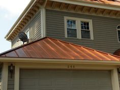 a house with a metal roof and two garage doors