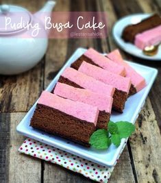 pink and brown cake sitting on top of a white plate next to a teapot