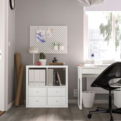 a white desk and chair in a small room with a window on the far wall