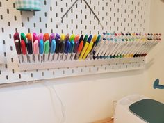 several pens are lined up on a peg board