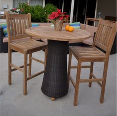 an outdoor table with two chairs around it and some fruit on the table next to it